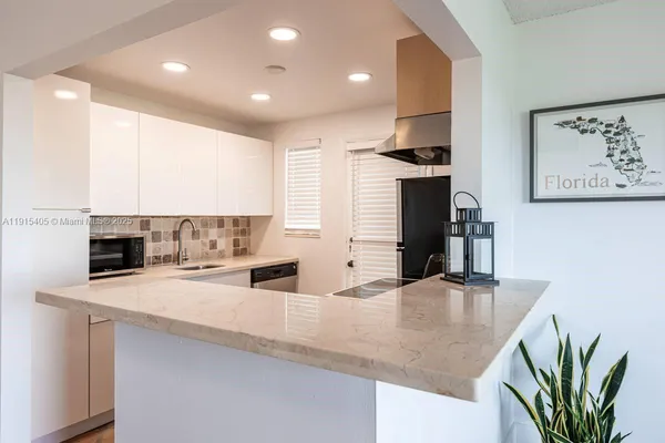 a kitchen with stainless steel appliances granite countertop a sink a stove and a refrigerator