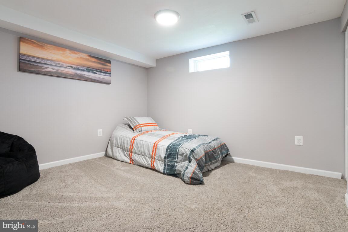 3613 Forest Hill Road Baltimore, MD 21207 - Photo 22 of 27 a spacious bedroom with a bed and a window