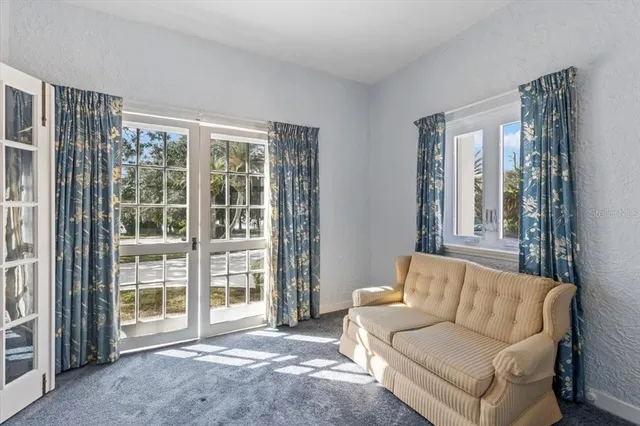 a view of an empty room with a window and wooden walls