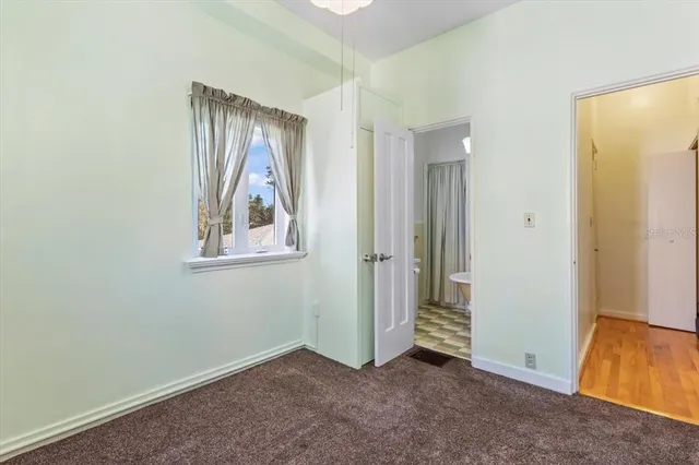 an empty room with windows and ceiling fan