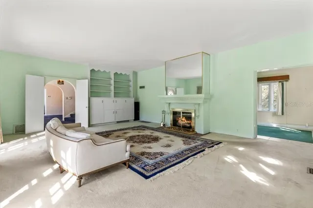 a view of an empty room with wooden floor and windows