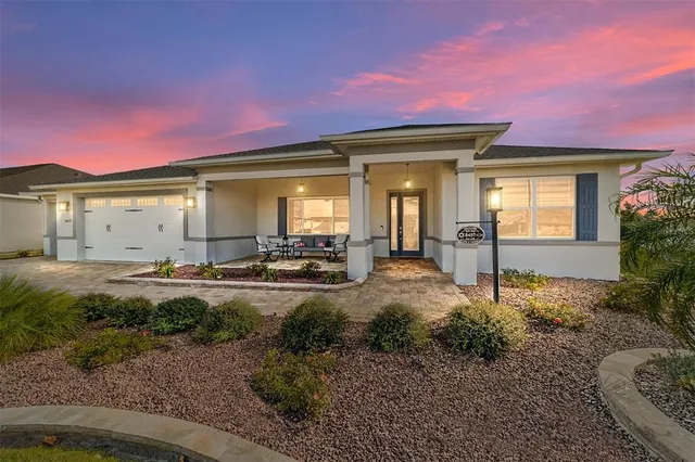 a view of a house with backyard and sitting area