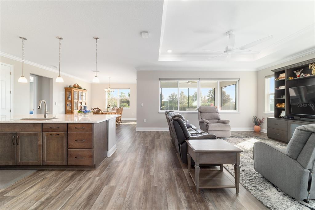 8457 Southwest 97th Circle Ocala, FL 34481 - Photo 11 of 62 a large living room with kitchen island granite countertop furniture a large window and a chandelier