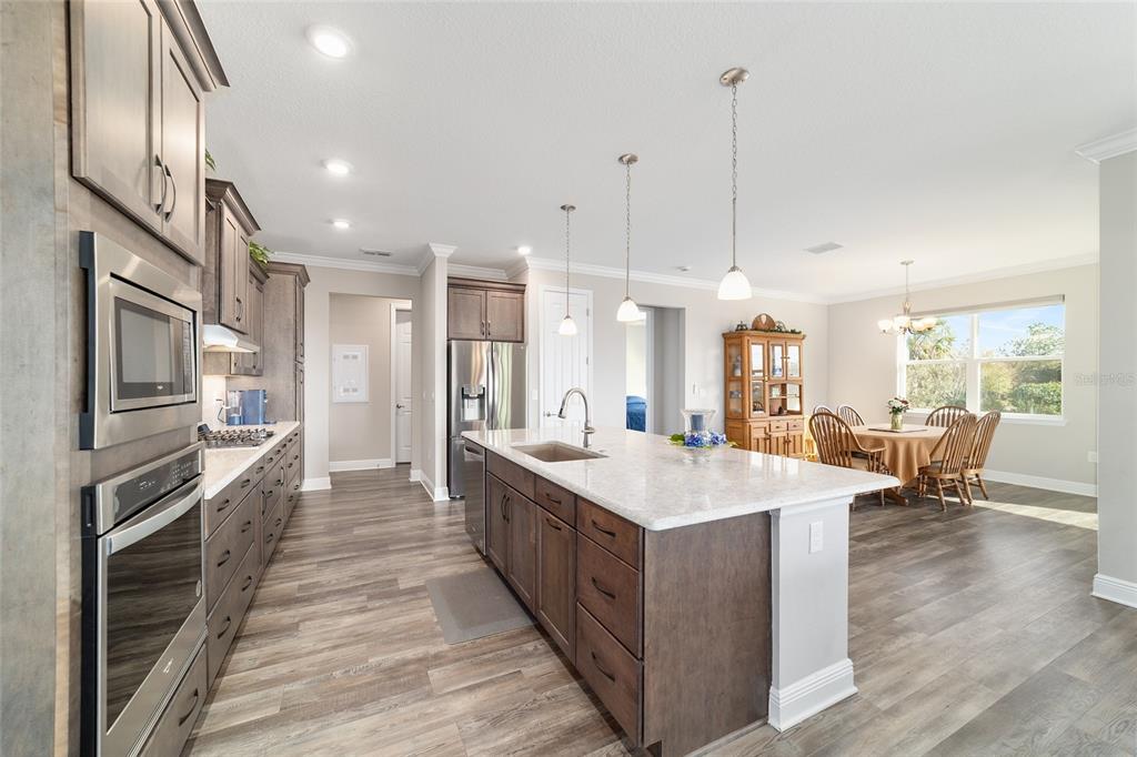 8457 Southwest 97th Circle Ocala, FL 34481 - Photo 19 of 62 a large kitchen with kitchen island a sink a stove and a refrigerator