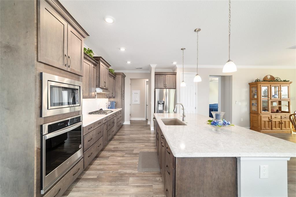 8457 Southwest 97th Circle Ocala, FL 34481 - Photo 20 of 62 a large kitchen with kitchen island a stove a sink a center island and cabinets