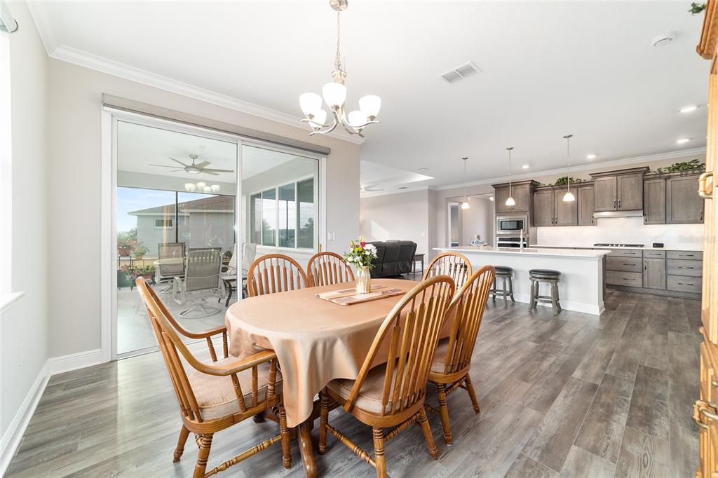 8457 Southwest 97th Circle Ocala, FL 34481 - Photo 33 of 62 a view of a dining room with furniture wooden floor and chandelier