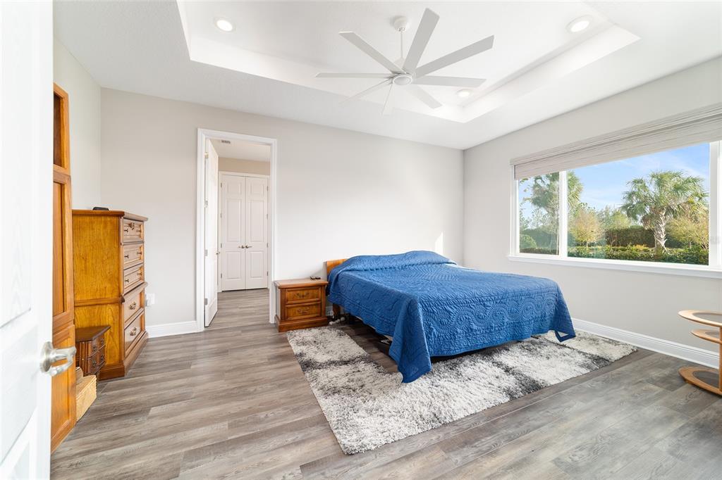 8457 Southwest 97th Circle Ocala, FL 34481 - Photo 34 of 62 a spacious bedroom with a bed and wooden floor