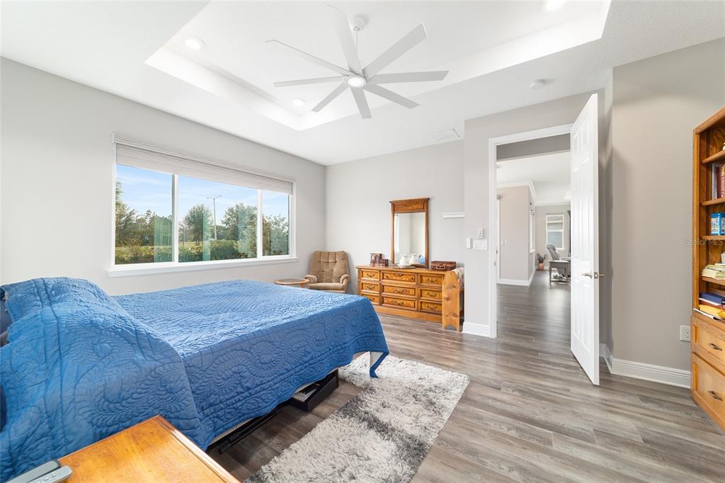 8457 Southwest 97th Circle Ocala, FL 34481 - Photo 36 of 62 a bedroom with a large bed and a chandelier