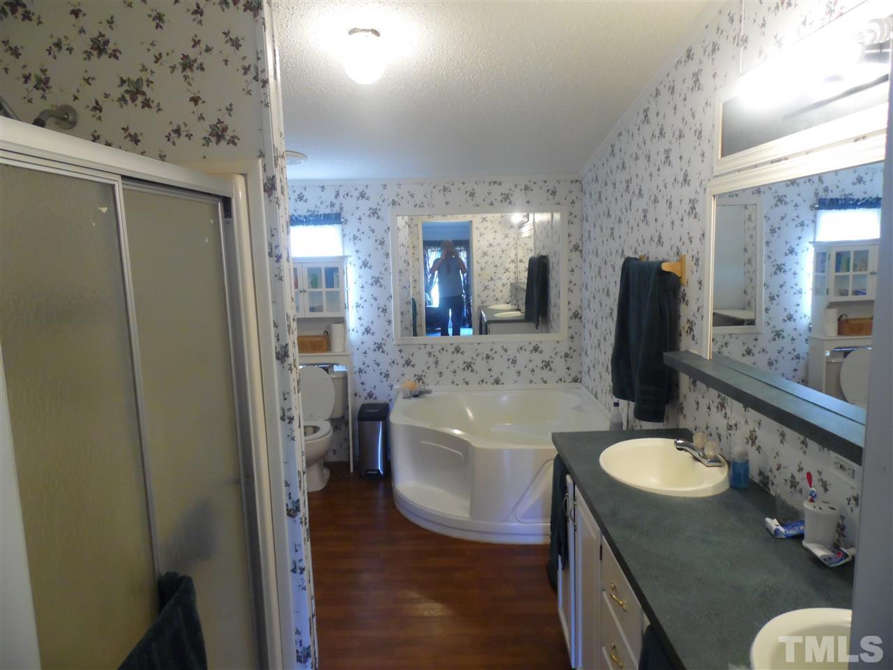 10582 Cone Road Middlesex, NC 27557 - Photo 18 of 25 a bathroom with a tub sink and mirror
