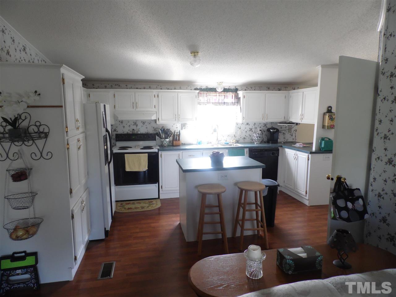 10582 Cone Road Middlesex, NC 27557 - Photo 7 of 25 a kitchen with stainless steel appliances granite countertop a refrigerator a sink dishwasher a stove and white countertops with wooden floor