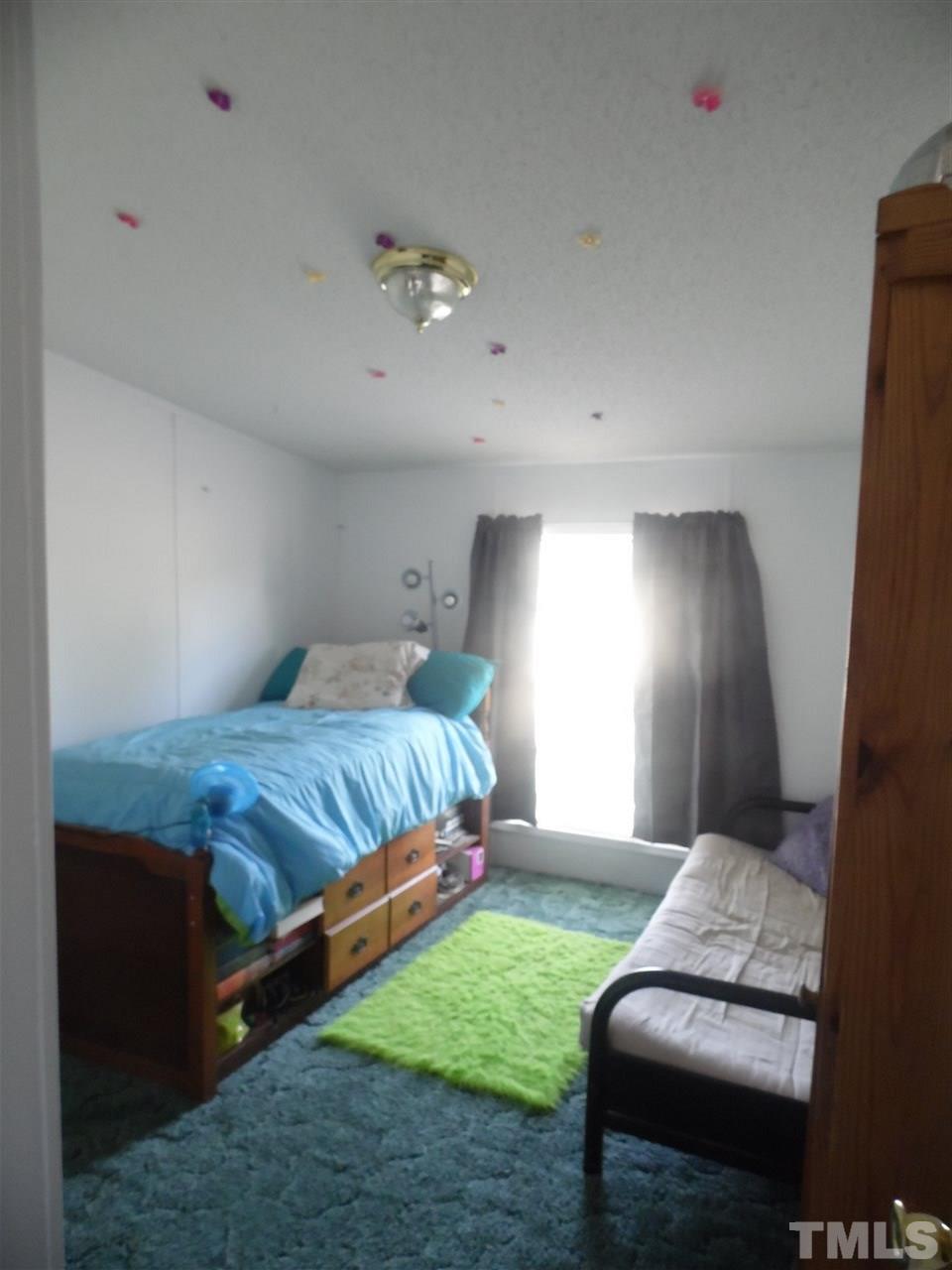 10582 Cone Road Middlesex, NC 27557 - Photo 10 of 25 a bedroom with a bed and chair