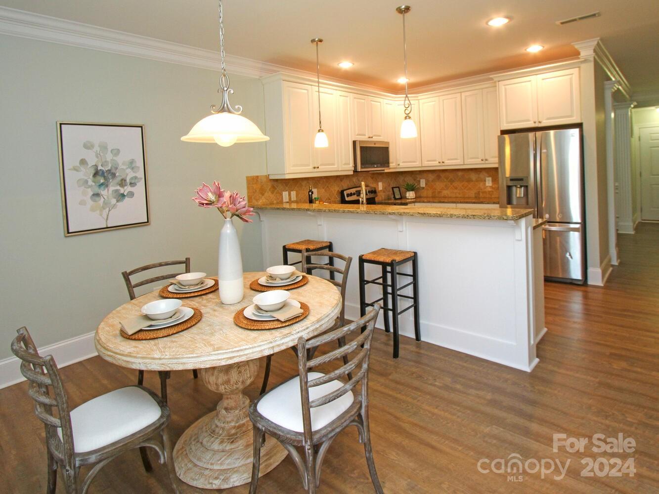 608 Crosswater Lane Fort Mill, SC 29708 - Photo 18 of 42 a kitchen with stainless steel appliances granite countertop a dining table chairs and a refrigerator