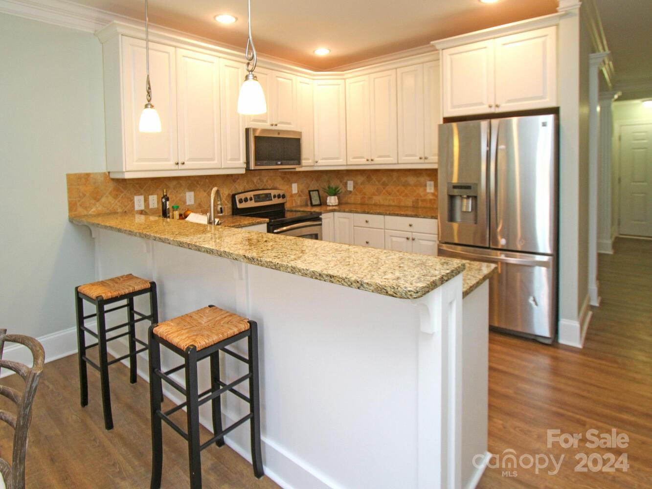 608 Crosswater Lane Fort Mill, SC 29708 - Photo 19 of 42 a kitchen with stainless steel appliances granite countertop a refrigerator a stove a sink and a microwave
