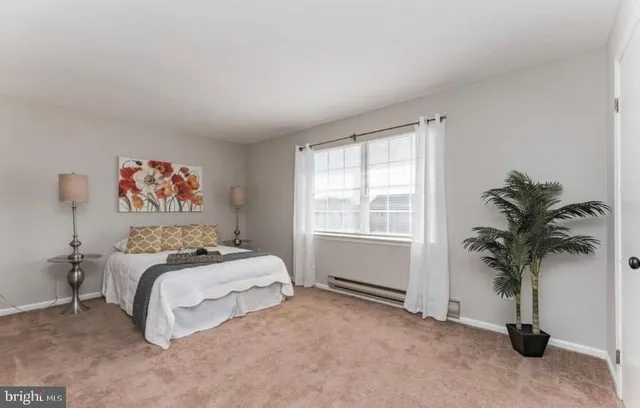 a bedroom with a bed and a potted plant