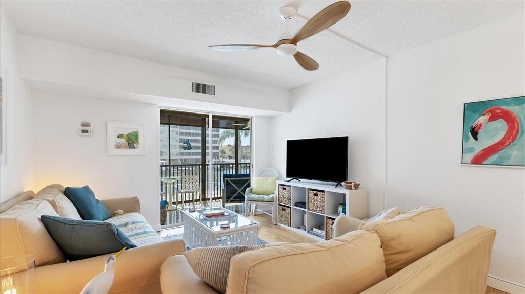 9200 Midnight Pass Road, Unit 24 Sarasota, FL 34242 - Photo 12 of 43 a living room with furniture and a flat screen tv