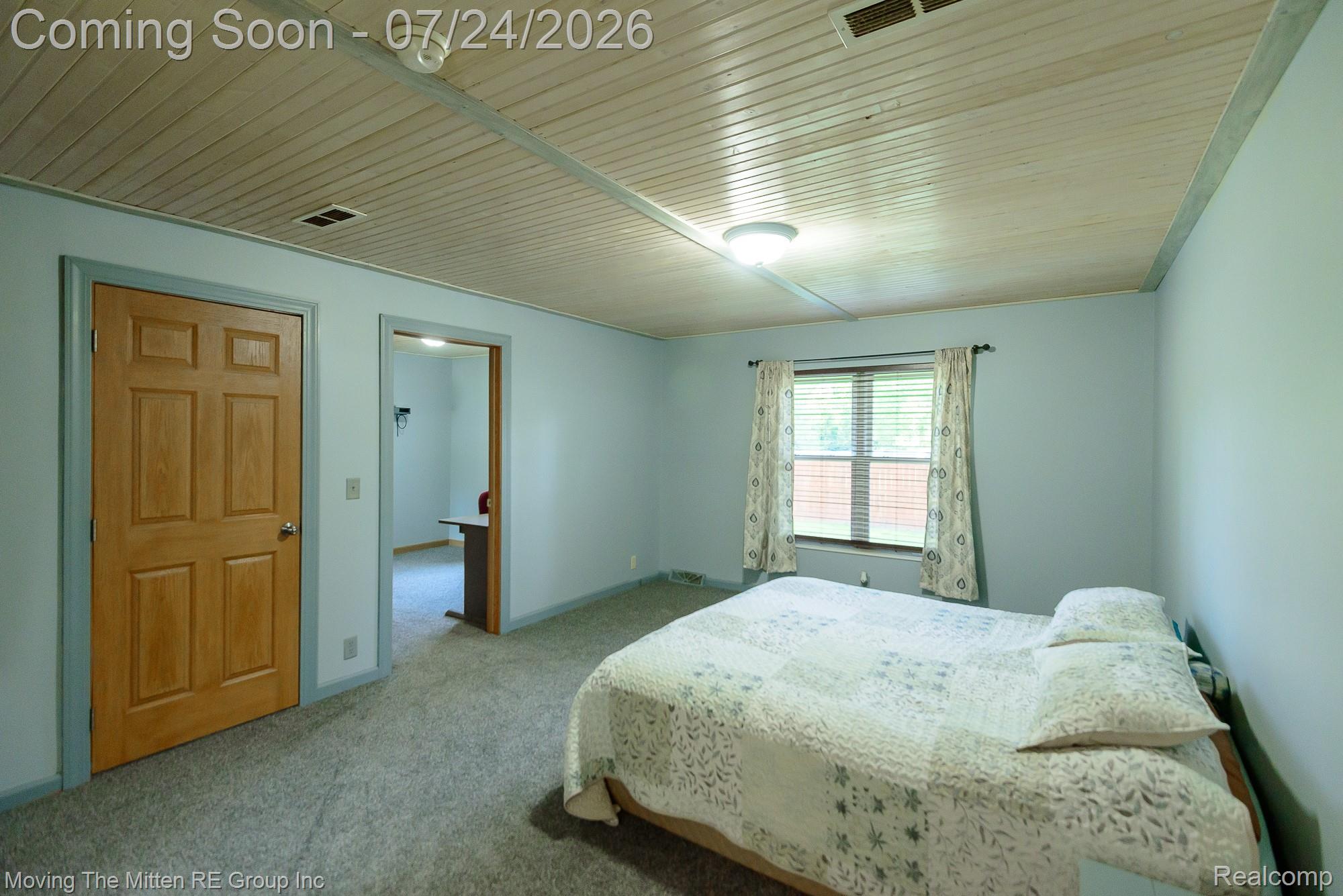 37460 Tyler Road Romulus, MI 48174 - Photo 23 of 52 Spacious room featuring light blue walls, grey carpet flooring, a natural wood-finish door, and a paneled ceiling