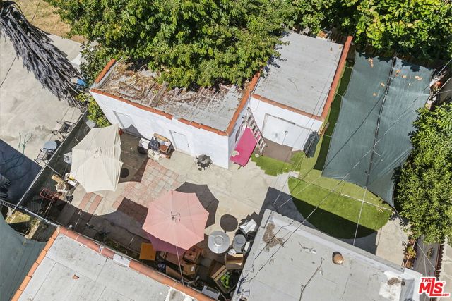 an aerial view of a house with a yard and large trees