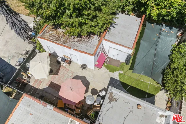 an aerial view of a house with a yard and large trees