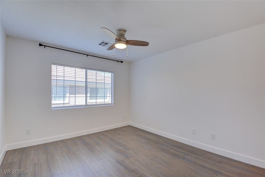10138 Rocky Tree Street Las Vegas, NV 89183 - Photo 18 of 43 Empty room with dark wood-type flooring and a ceiling fan