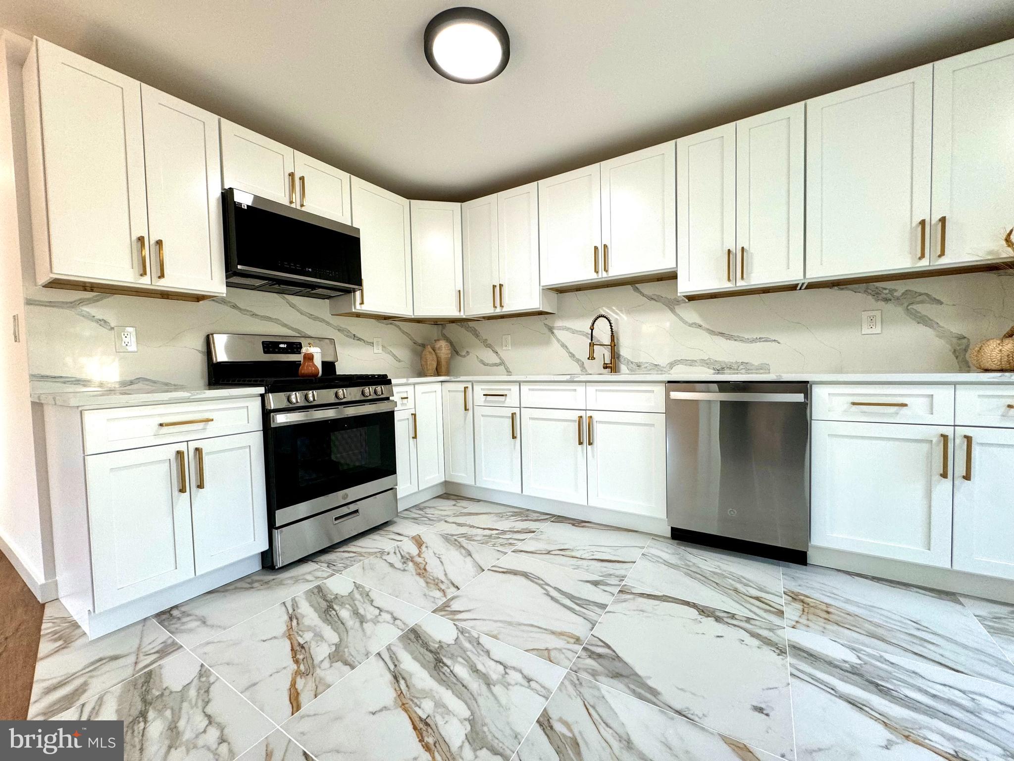 3 Mint Leaf Drive Hamilton, NJ 08690 - Photo 9 of 33 a kitchen with granite countertop a sink a stove and cabinets