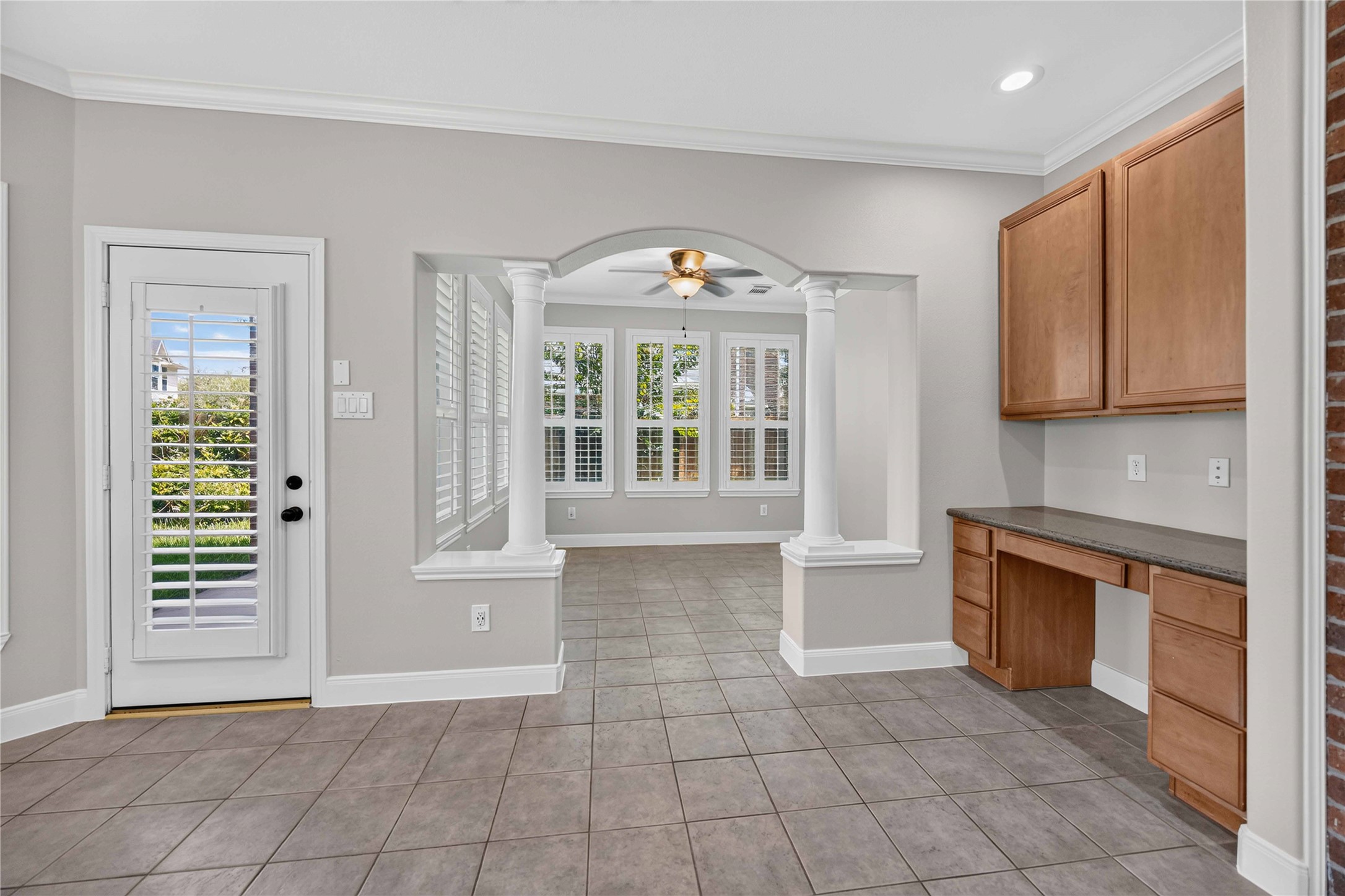 3303 Raleigh Row Missouri City, TX 77459 - Photo 20 of 50 Bright and airy space featuring elegant archways to Sunroom, a built-in workspace with ample cabinetry, and large windows with plantation shutters that invite natural light.