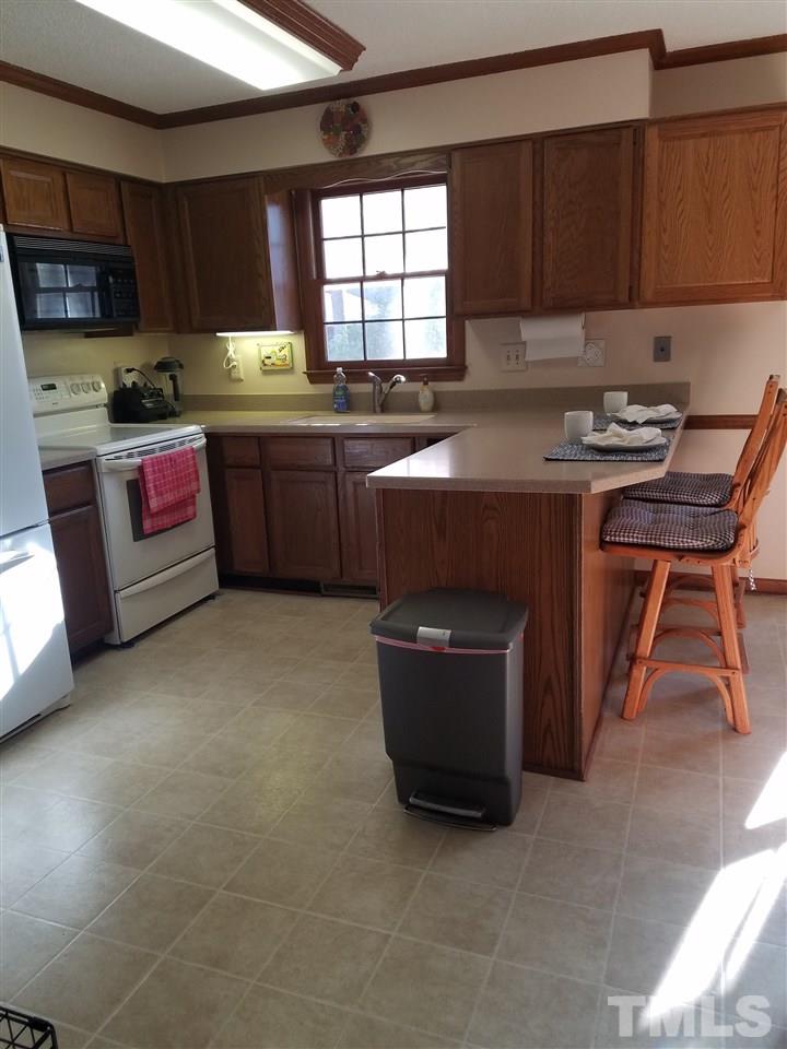 7329 Mill Ridge Road Raleigh, NC 27613 - Photo 13 of 25 a kitchen with stainless steel appliances granite countertop a stove a sink dishwasher and a microwave oven with cabinets