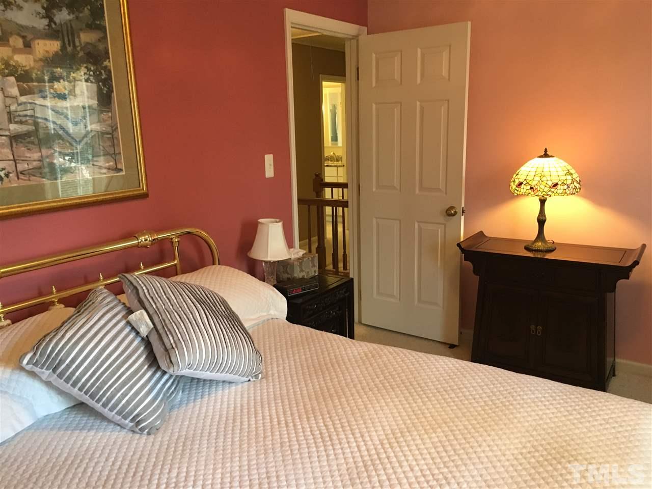 7329 Mill Ridge Road Raleigh, NC 27613 - Photo 16 of 25 a bedroom with a bed and a chandelier