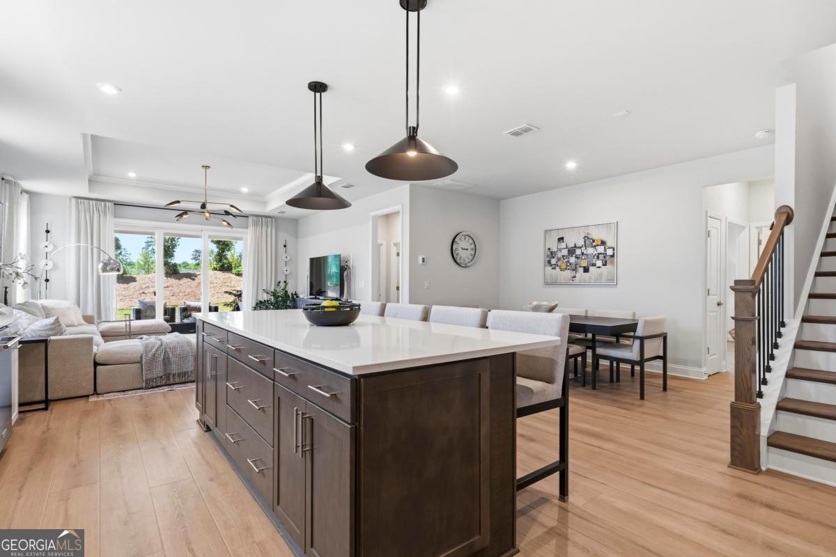 1190 Little Shls Road Greensboro, GA 30642 - Photo 16 of 44 a kitchen with stainless steel appliances kitchen island a dining table chairs and a wooden floor