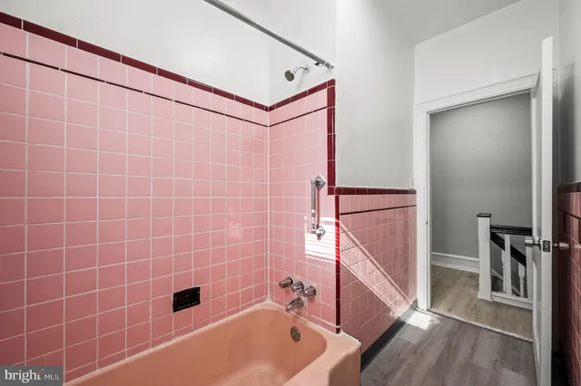 a bathroom with a tub a toilet and a shower