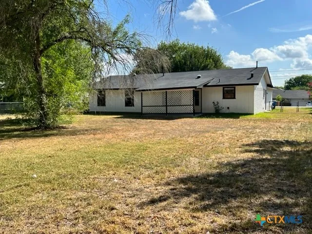 a house with yard and wooden fence