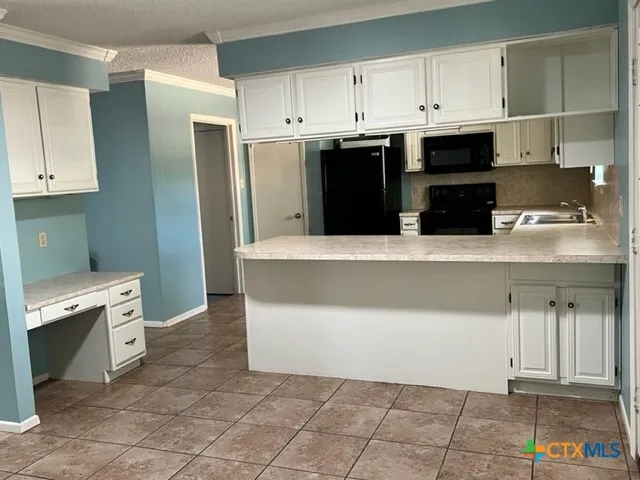 a kitchen with cabinets and appliances