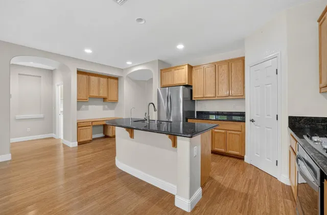 a kitchen with stainless steel appliances granite countertop a stove a sink and a refrigerator