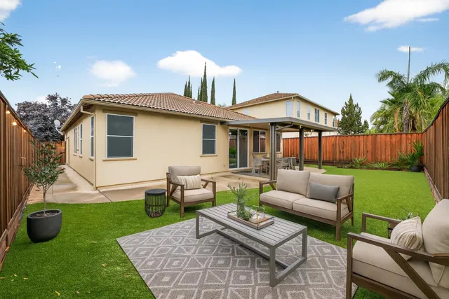 a view of a house with a yard and patio