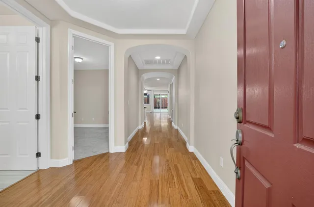 a view of a hallway with wooden floor and staircase