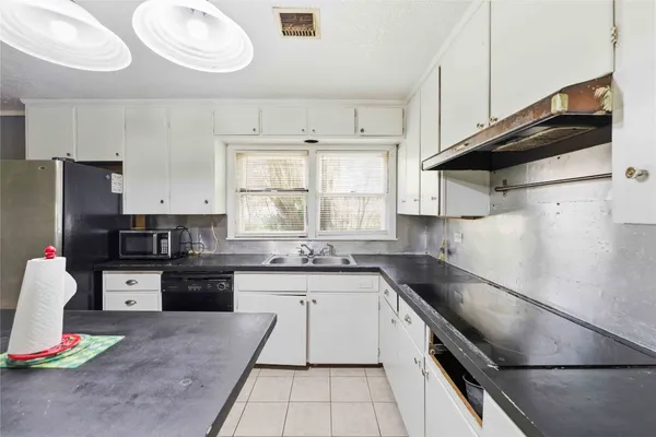 a kitchen with granite countertop stainless steel appliances a sink a stove and a refrigerator