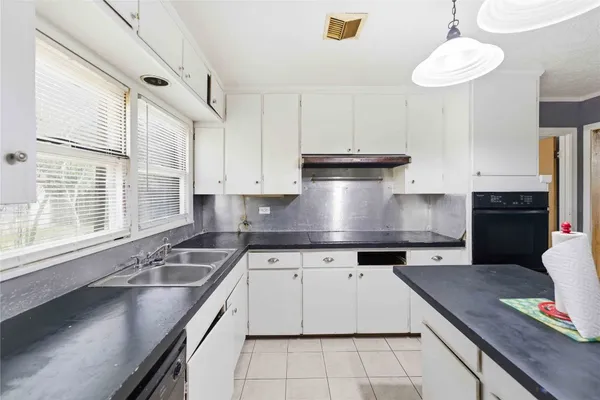 a kitchen with kitchen island granite countertop a sink a counter space appliances and cabinets