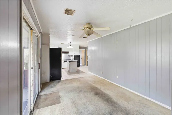 a view of a kitchen with refrigerator and a ceiling fan