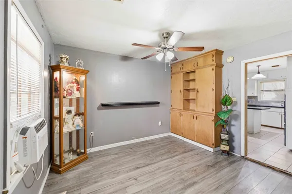 a view of a hallway with wooden floor and a kitchen