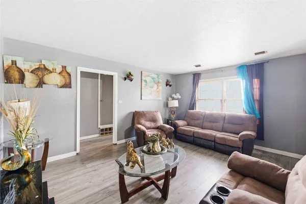 a living room with furniture and wooden floor