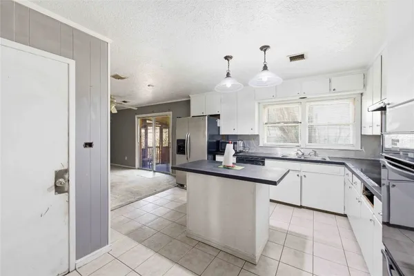 a kitchen with white cabinets appliances and a fireplace
