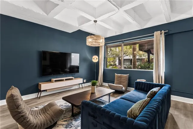 a living room with furniture a flat screen tv and a window