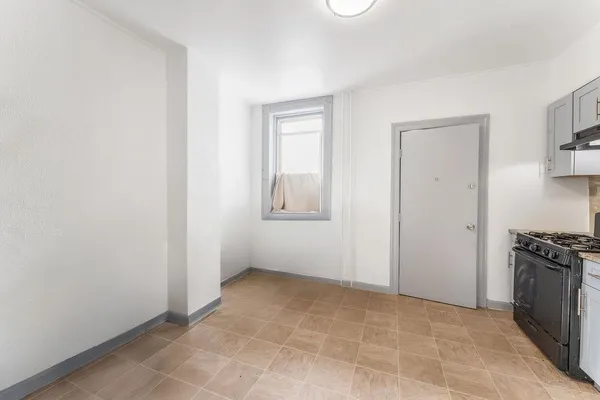 a view of a kitchen with an empty space and a window