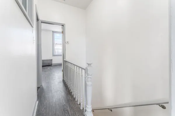 a view of a hallway with wooden floor and entryway