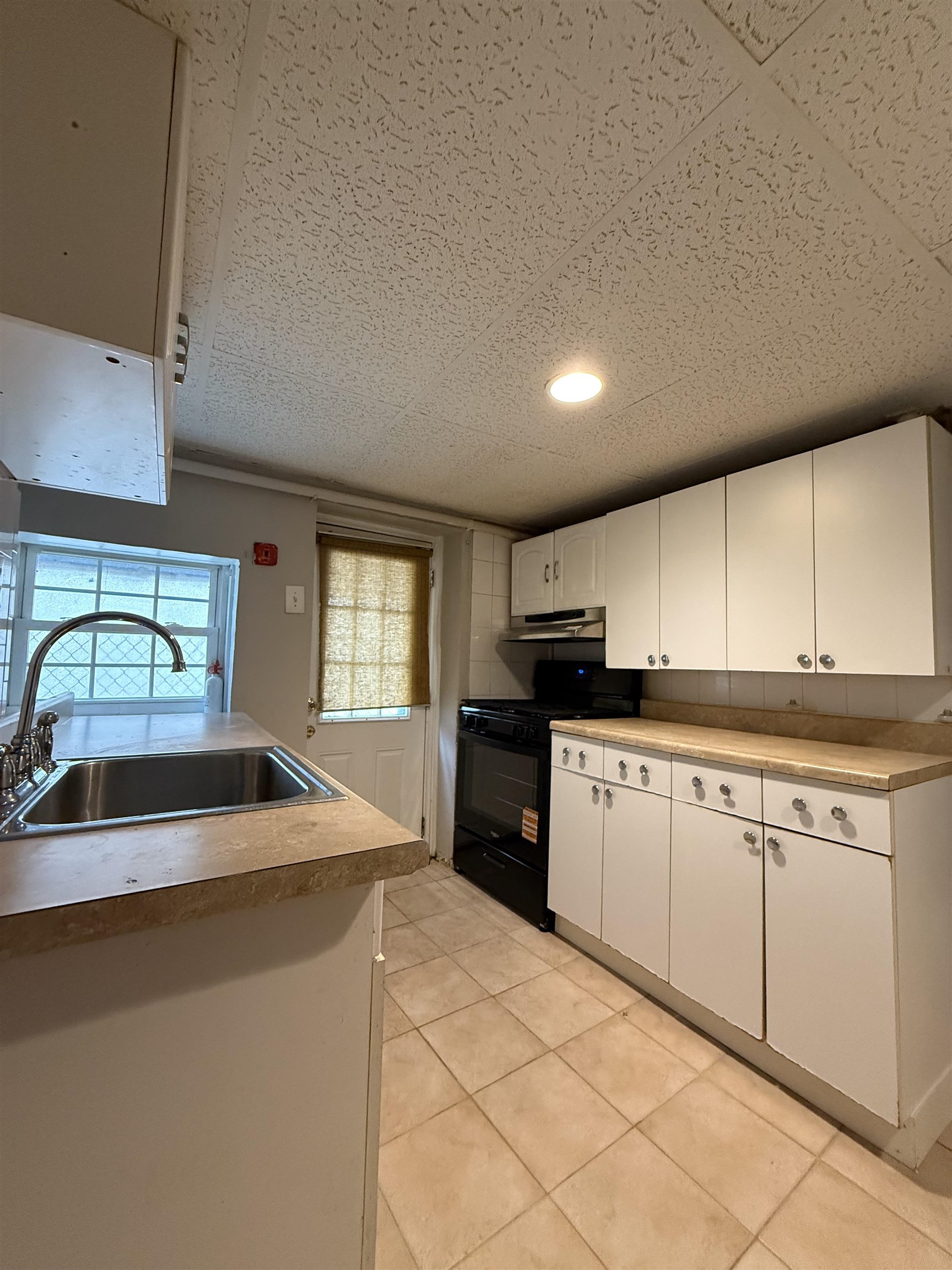 1430 44th Street, Unit 1 North Bergen, NJ 07047 - Photo 3 of 9 a kitchen with granite countertop a sink a stove top oven and cabinetry