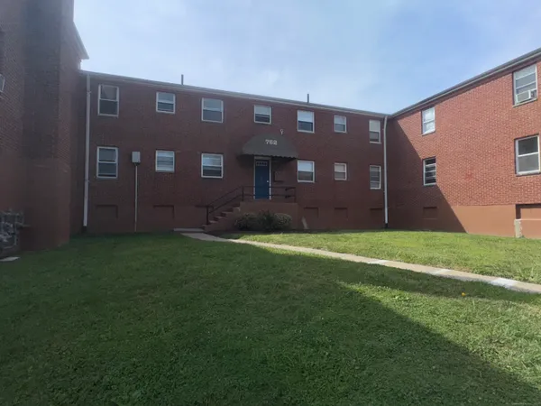 a brick building with a yard in front of it