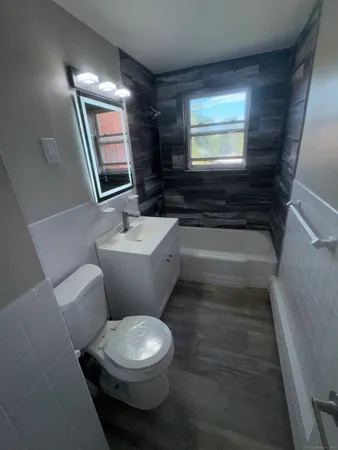 a bathroom with a toilet a sink and a mirror