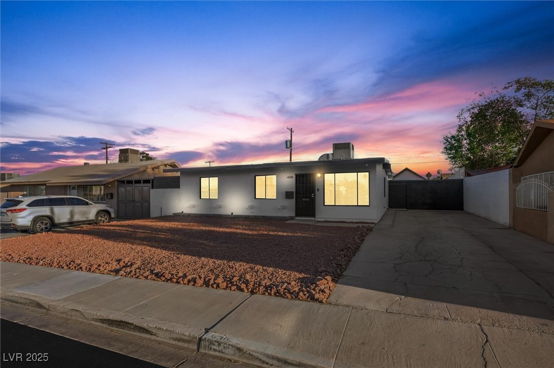 Ranch-style home featuring driveway and stucco siding