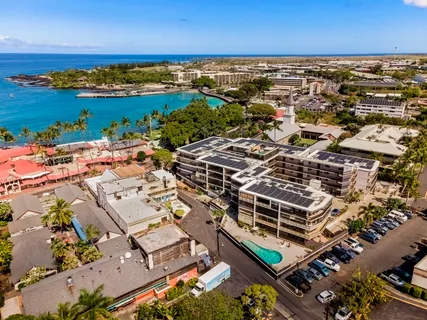 an aerial view of a building with outdoor space and ocean view
