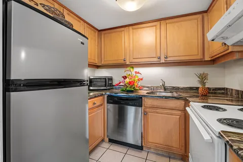 a kitchen with stainless steel appliances granite countertop a refrigerator and a stove top oven
