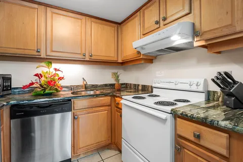 a kitchen with stainless steel appliances granite countertop a sink stove and cabinets